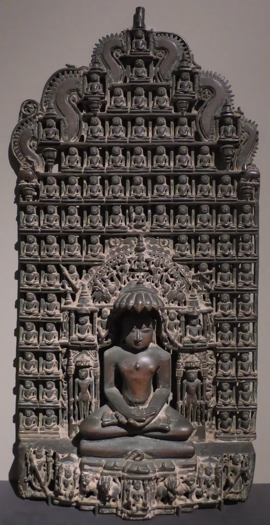 A metal altarpiece from around 1500 crowded with small seated Jina figures
